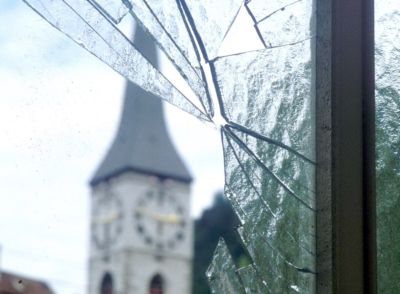 Eingeschlagenes Fenster, im Hintergrund die Churer Martinskirche