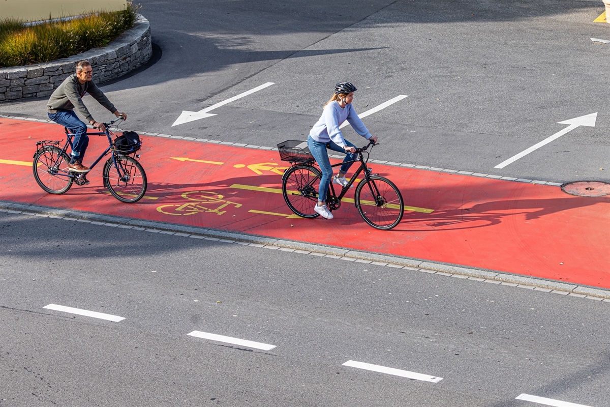 Eine Velofahrerin und ein Velofahrer auf dem Velostreifen