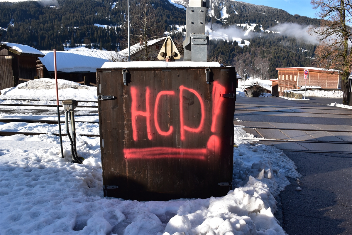 Sprayerei auf Holzkasten beim Bahnübergang in Klosters Dorf