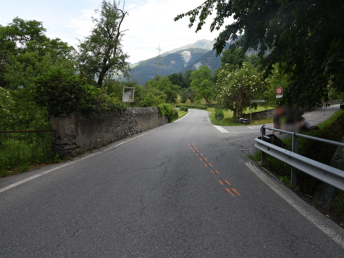 Unfallörtlichkeit auf der Domleschgerstrasse mit rechtsseitiger Einmündung der Verbindungsstrasse vom Schulheim Scalottas. Auf der Domleschgerstrasse Bremsspur des Motorrades.