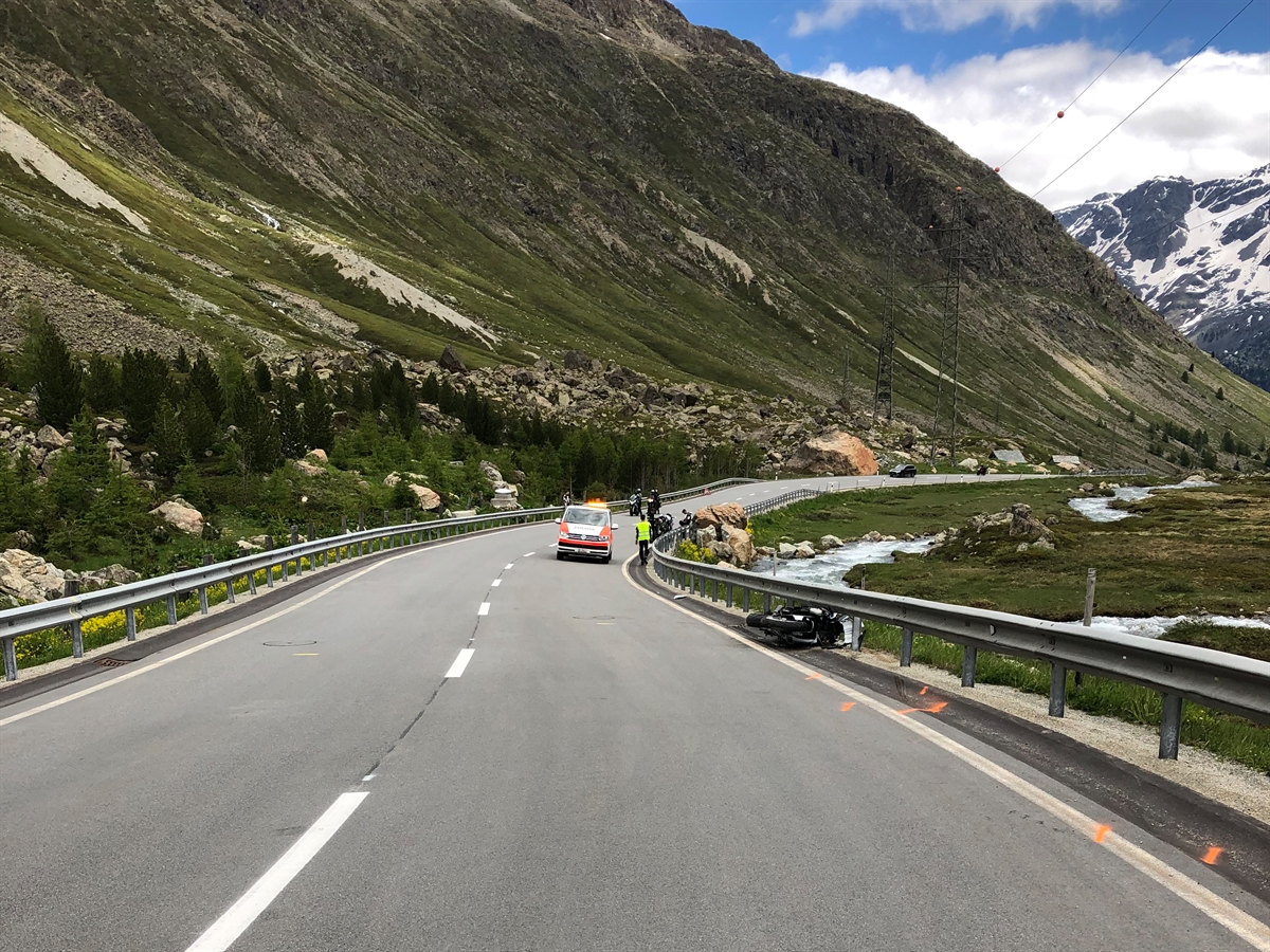 Unfallörtlichkeit in der Rechtskurve. Motorrad liegt massiv beschädigt unter der Leitplanke.