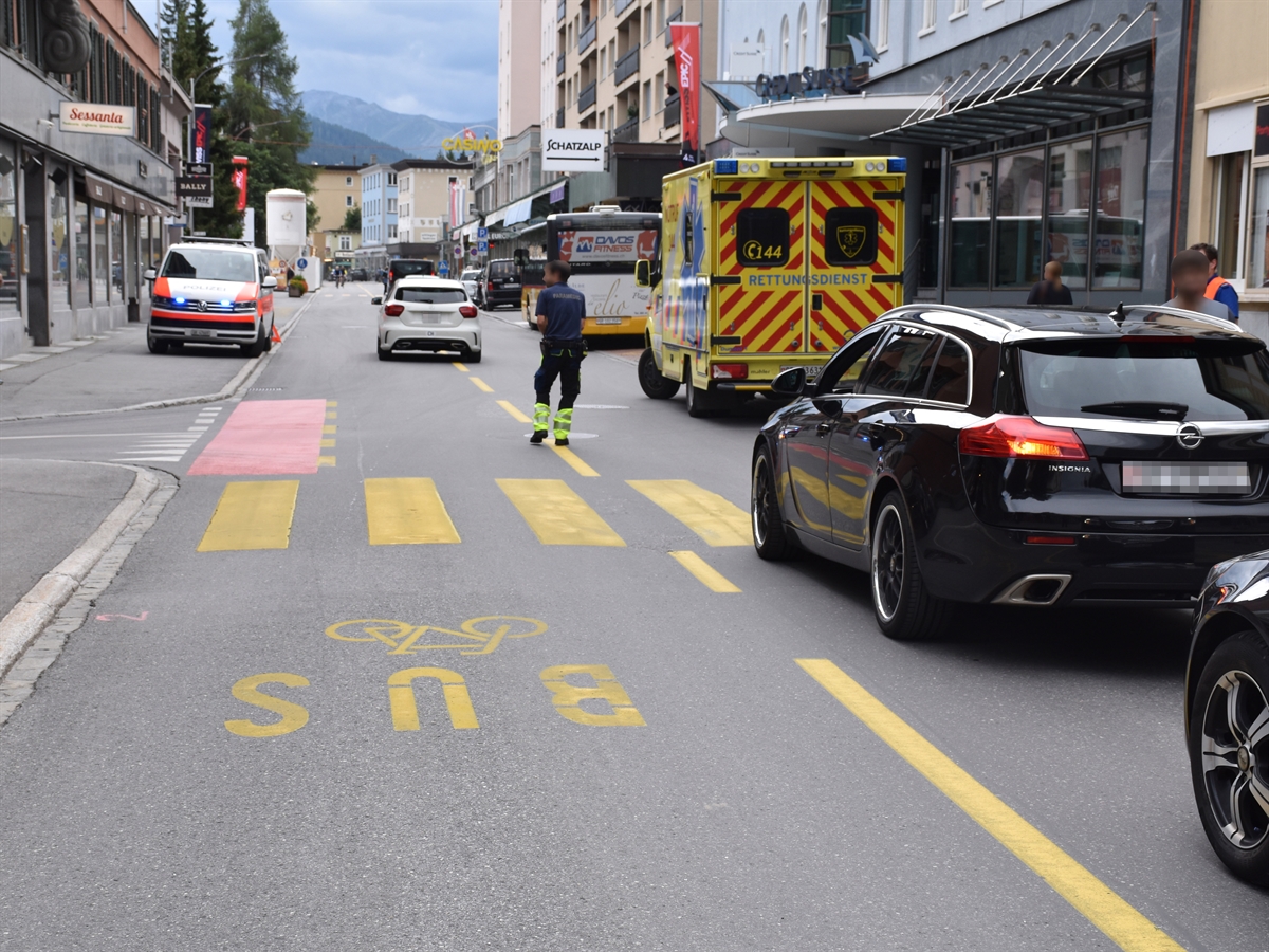 Unfallörtlichkeit auf der Promenade in Davos mit Fussgängerstreifen, Ambulanz und Patrouillenfahrzeug.