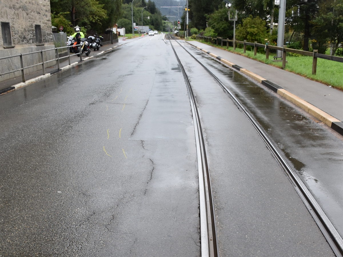 Die Nasse Fahrbahn in Le Prese mit der Gleisanlage auf der rechten Fahrbahnhälfte.