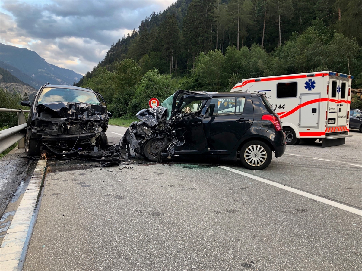 Zwei total beschädigte frontal kollidierte Personenwagen und Ambulanz