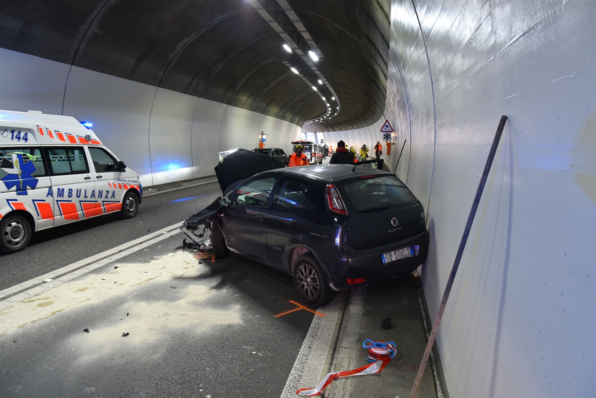 An der Front total beschädigtes Auto mit dem Heck rechts zur Tunnelwand. Links davon eine Ambulanz.