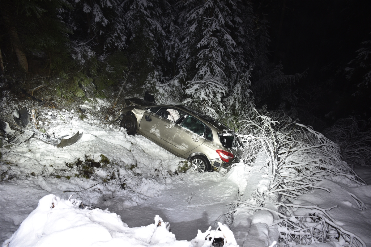 Das Unfallauto liegt auf den Rädern im Abhang im verschneiten Wald