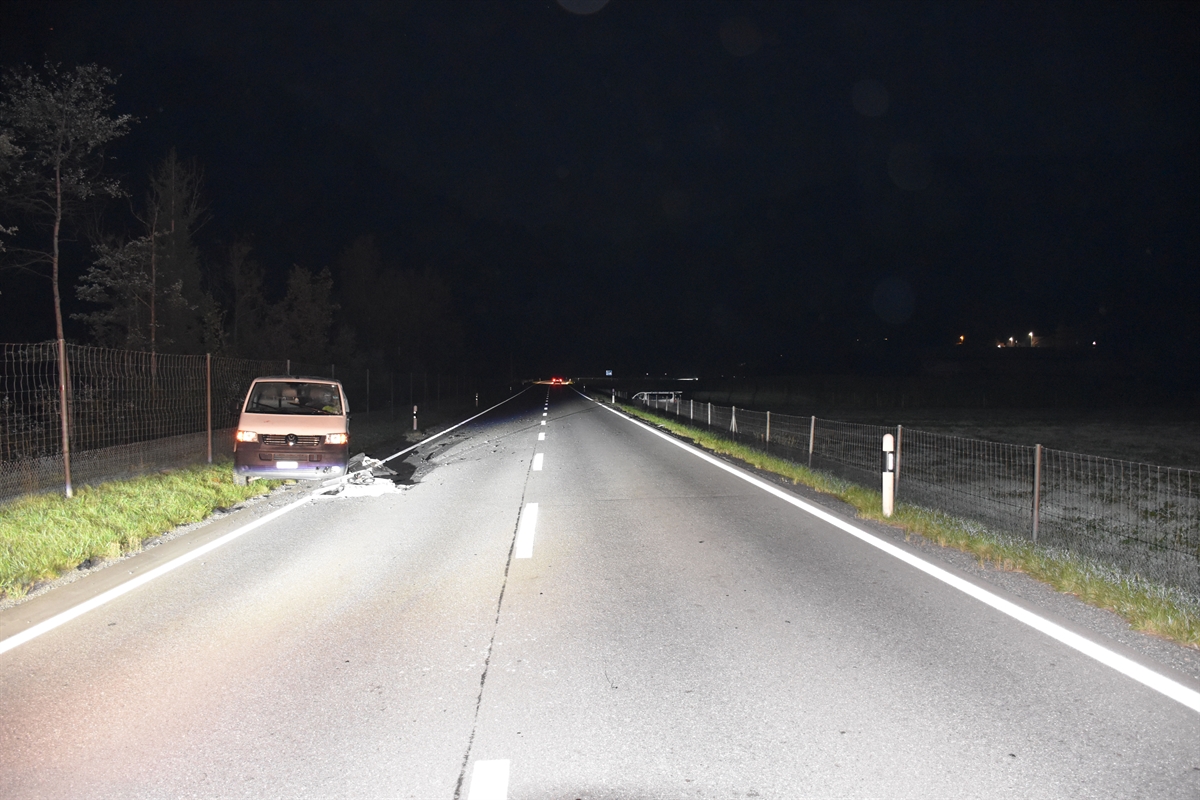 Gerade übersichtliche Strasse. Ein Fahrzeug links an der Strasse, das andere im Hintergrund in einer Wiese.