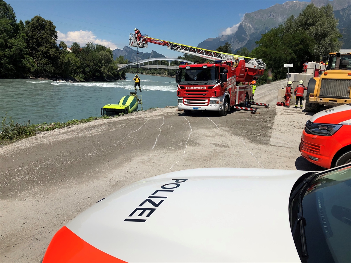 An einem Hubretter wird ein Feuerwehrmann zum Lastwagen abgeseilt. Im Vordergrund stehen zwei Polizeifahrzeuge.