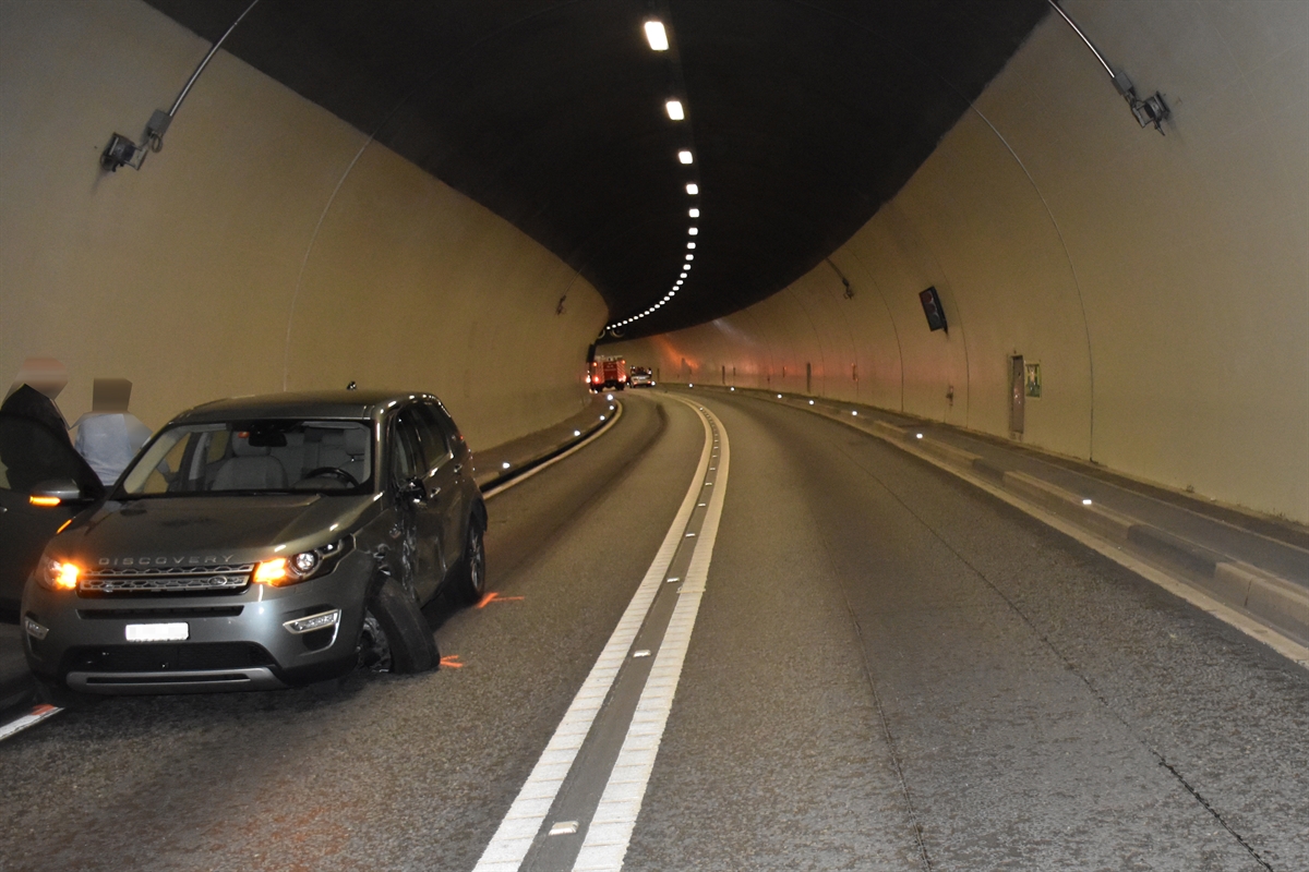 Das an der Radaufhängung vorne links und seitlich stark beschädigte Auto am linken Strassenrand im Tunnel.