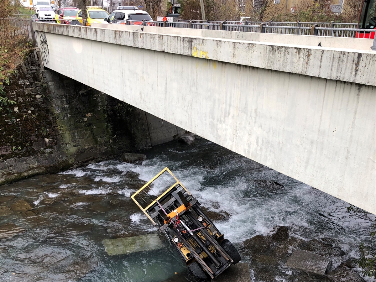 Schräg-seitliche Aufnahme der Fussgängerbrücke. Unterhalb dieser liegt der Gabelstapler auf dem Dach in der Plessur.