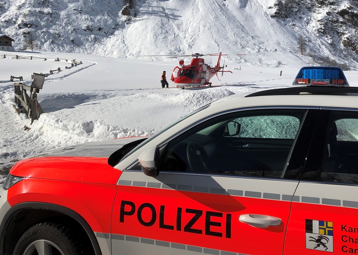 Winterlandschaft mit Polizeifahrzeug und Rega Helikopter 