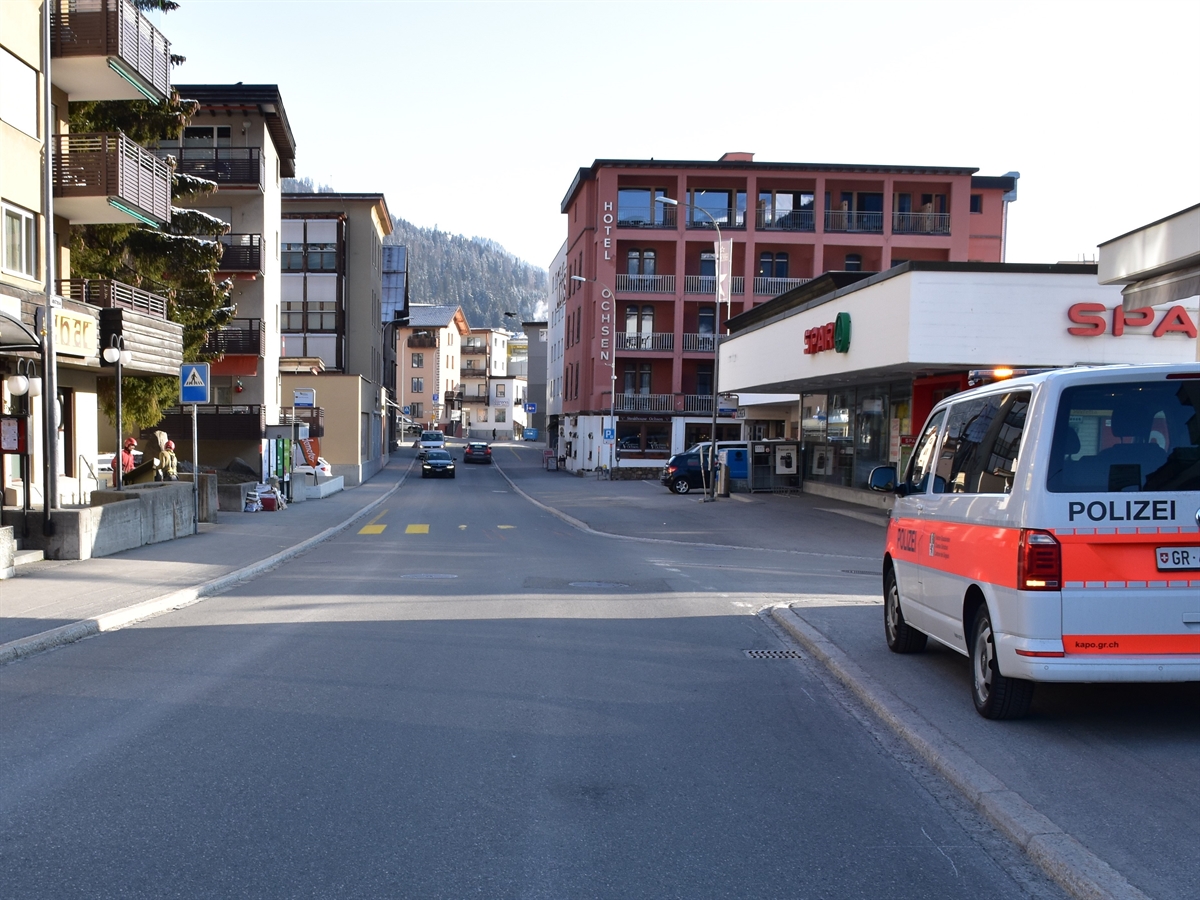 Rechts ein Polizeiauto und die einmündende Skistrasse. In Bildmitte der Fussgängerstreifen auf der Talstrasse, auf welchem die Jugendliche vom Auto erfasst wurde.
