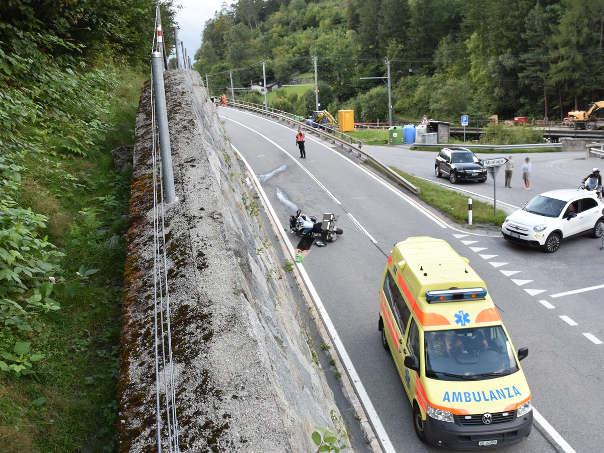Aufnahme von einer Stützmauer auf die Strasse hinunter. Im Vordergrund das Ambulanzfahrzeug, links davon liegt das Motorrad auf der Strasse.  
