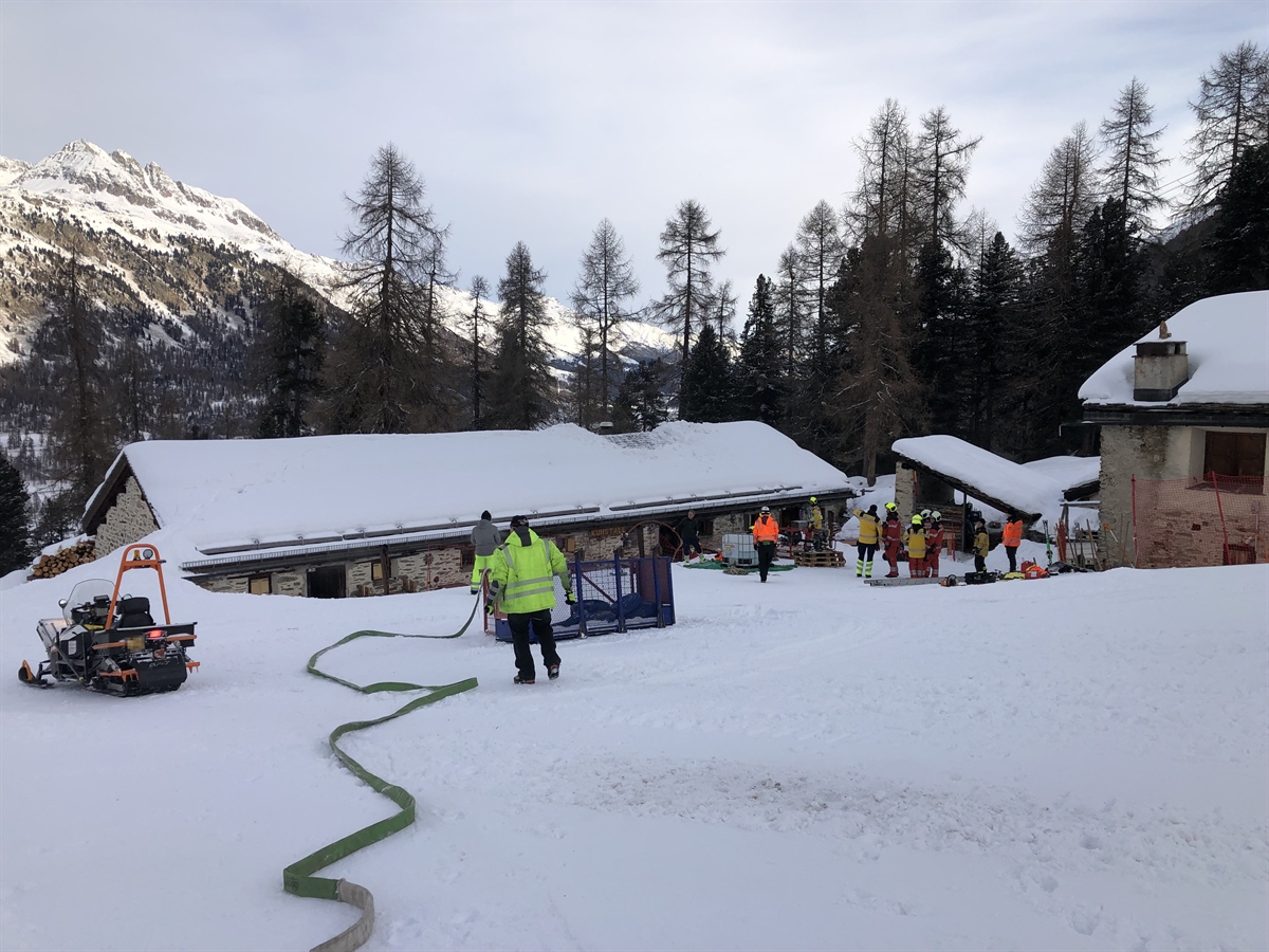 Feuerwehrleute im Schnee vor dem Bergrestaurant