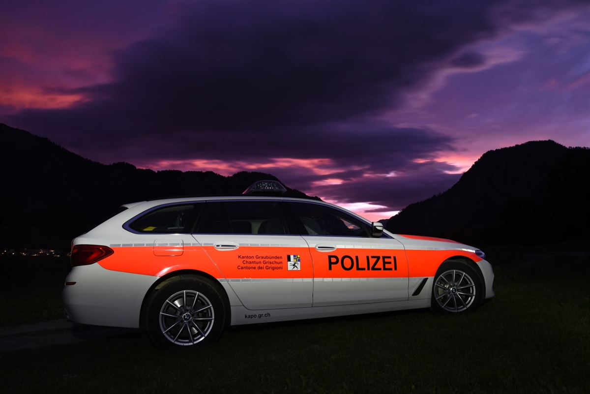Angeschriebenes Polizeifahrzeug im Vordergrund. Im Hintergrund bewölkter Himmel mit Morgenrot.