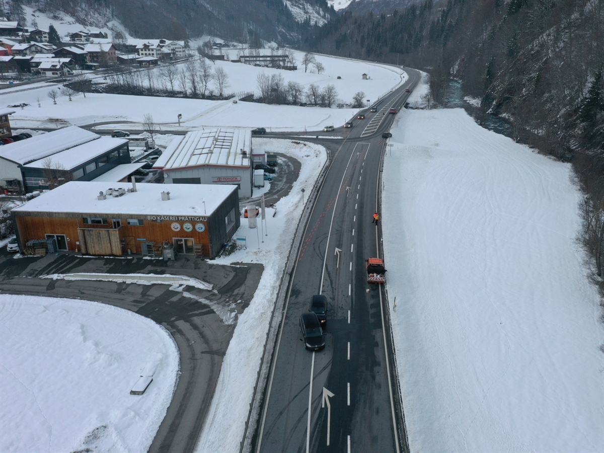 Drohnenaufnahme der Unfallstelle mit den involvierten Fahrzeugen auf der Strasse sowie einem Fahrzeug des Kantonalen Tiefbauamtes.