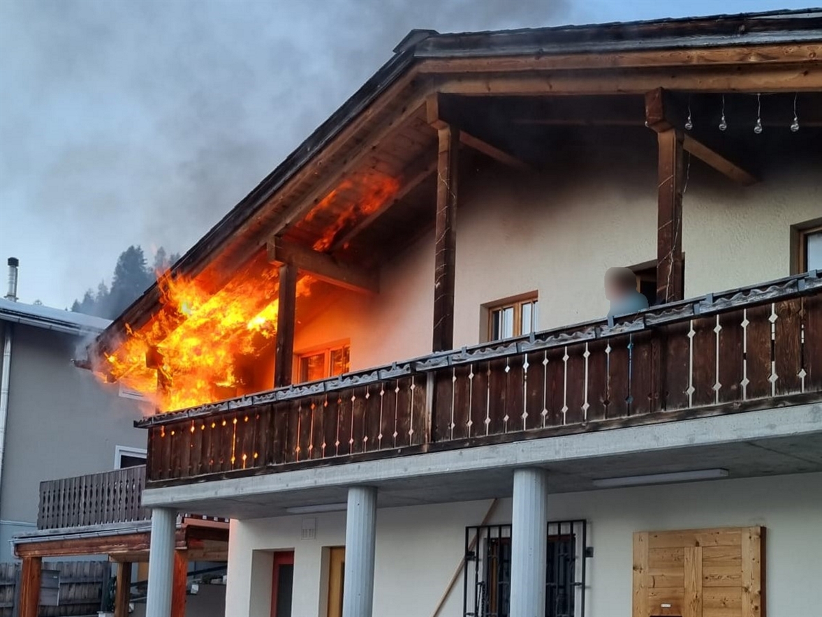 Flammen am linken Rand des Balkons, welche bis zum Vordach des Hauses hochsteigen.