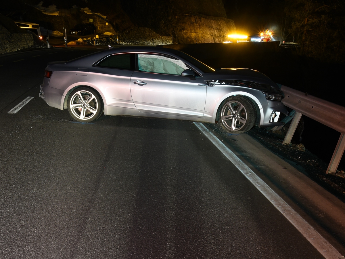 Die linke Seite des silbernen Autos. Es steht mit der Front nach rechts an der Leitplanke. Im Hintergrund eine Kurve. 