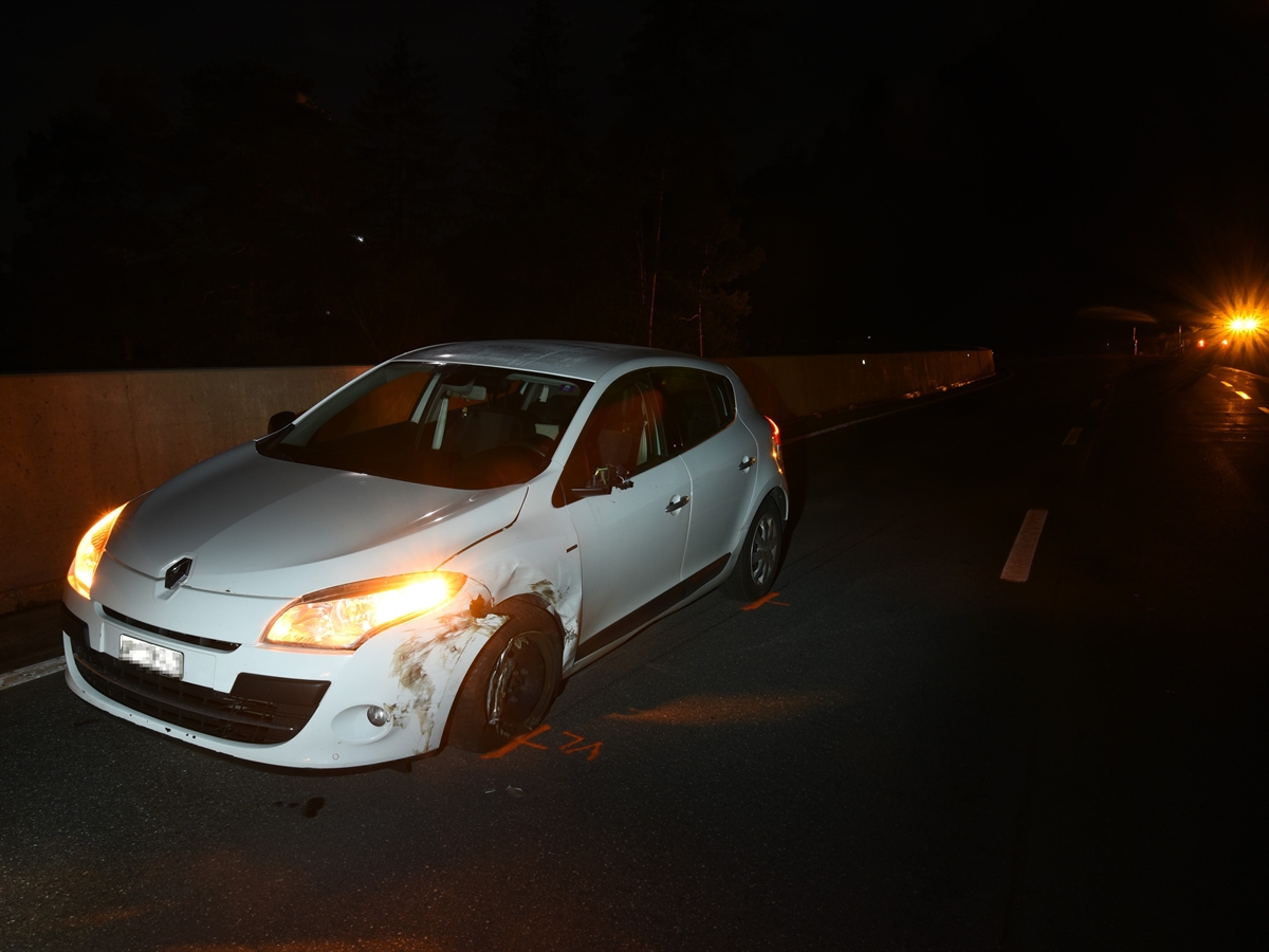 Blick von schräg vorne auf die linke Seite des Autos. Es steht nahe am Strassenrand, die Radaufhängung vorne links ist nach hinten verschoben. 