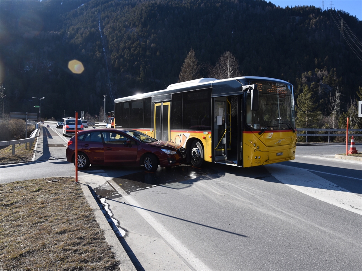 Die Querverbindung beim Anschluss Rothenbrunnen mit dem Postauto sowie dem beteiligten Personenwagen. Im Hintergrund ein Patrouillenfahrzeug der Kantonspolizei Graubünden