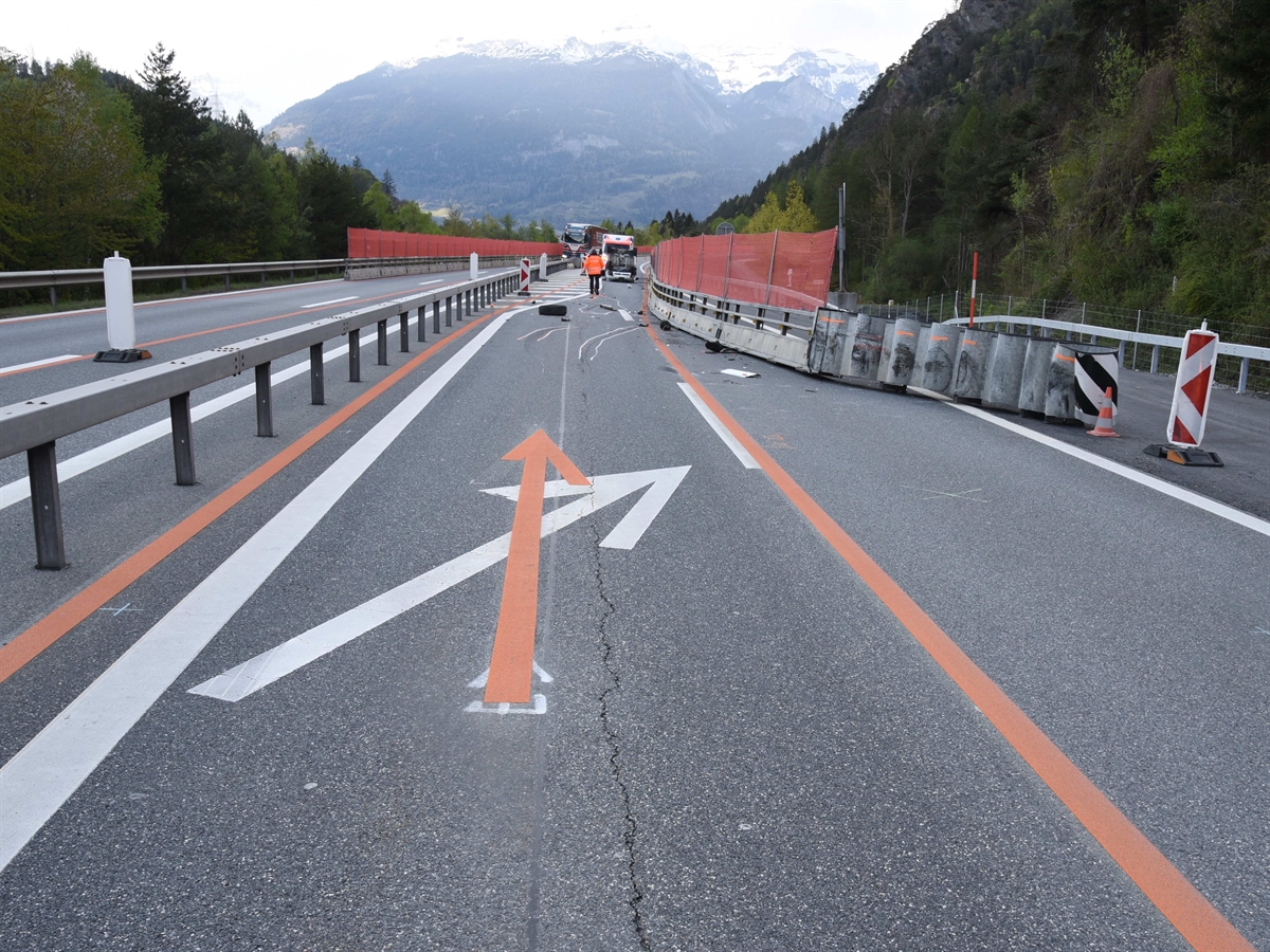 Aufnahme innerhalb der Baustelle in Fahrtrichtung, orange temporäre Bodenmarkierungen, rechts der beschädigte Aufpralldämpfer. 