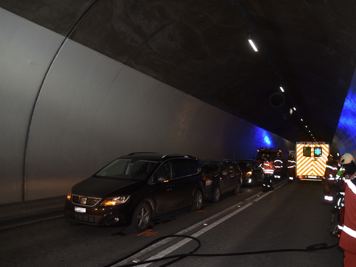Aufnahme im Tunnel. Links von schräg vorne die drei beteiligten Autos und rechts davon die Einsatzkräfte.