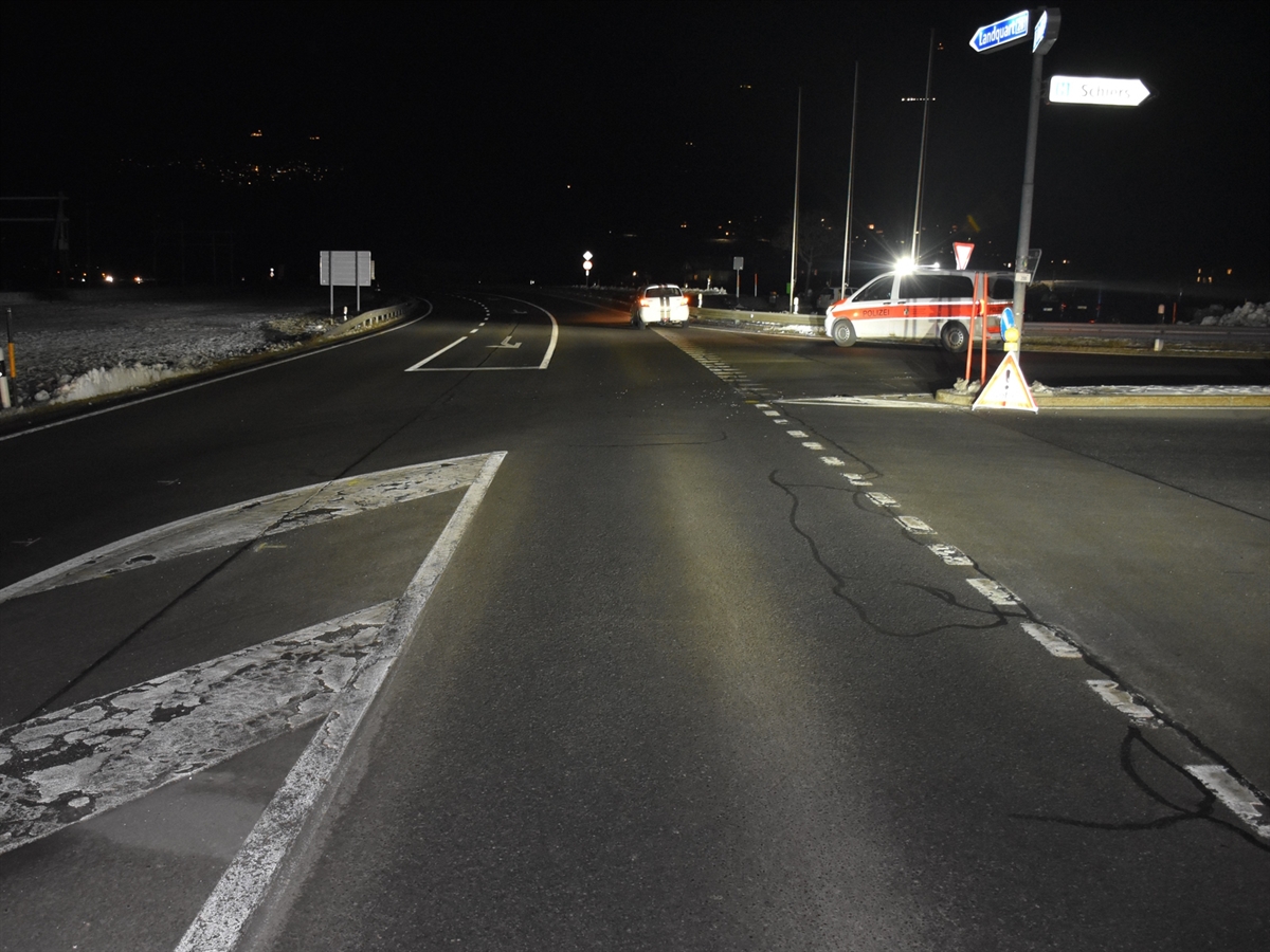 Aufnahme in der Dunkelheit. Die Verzweigung, an welcher rechts ein Polizeiauto und weiter entfernt das eine der beiden Unfallautos steht.