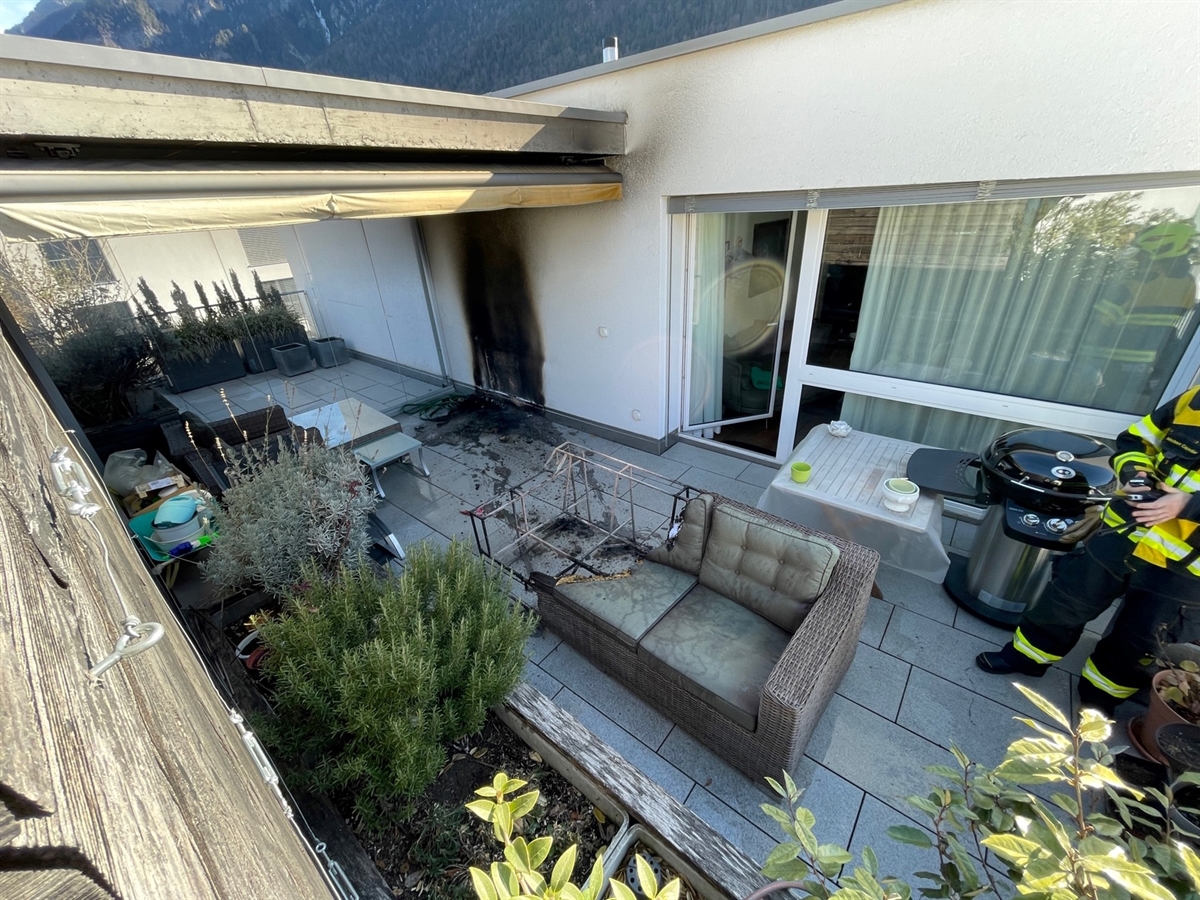Der Balkon mit der verbrannten Couch. An der Hausfassade Russablagerungen und Brandschaden.