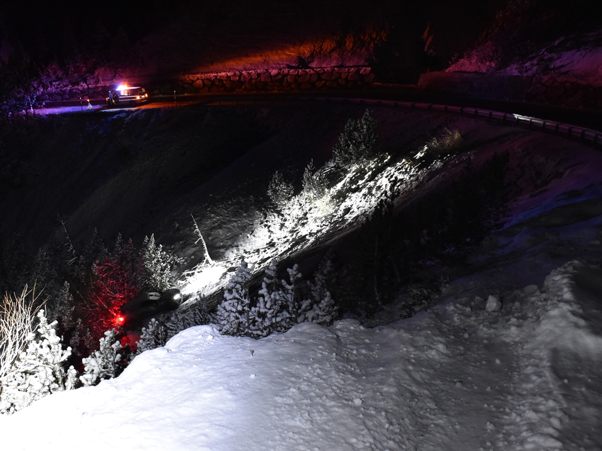 Im Vordergrund Spuren im Schnee, welche beim im Hang stehenden Auto enden. Im Hintergrund ein Polizeiauto.