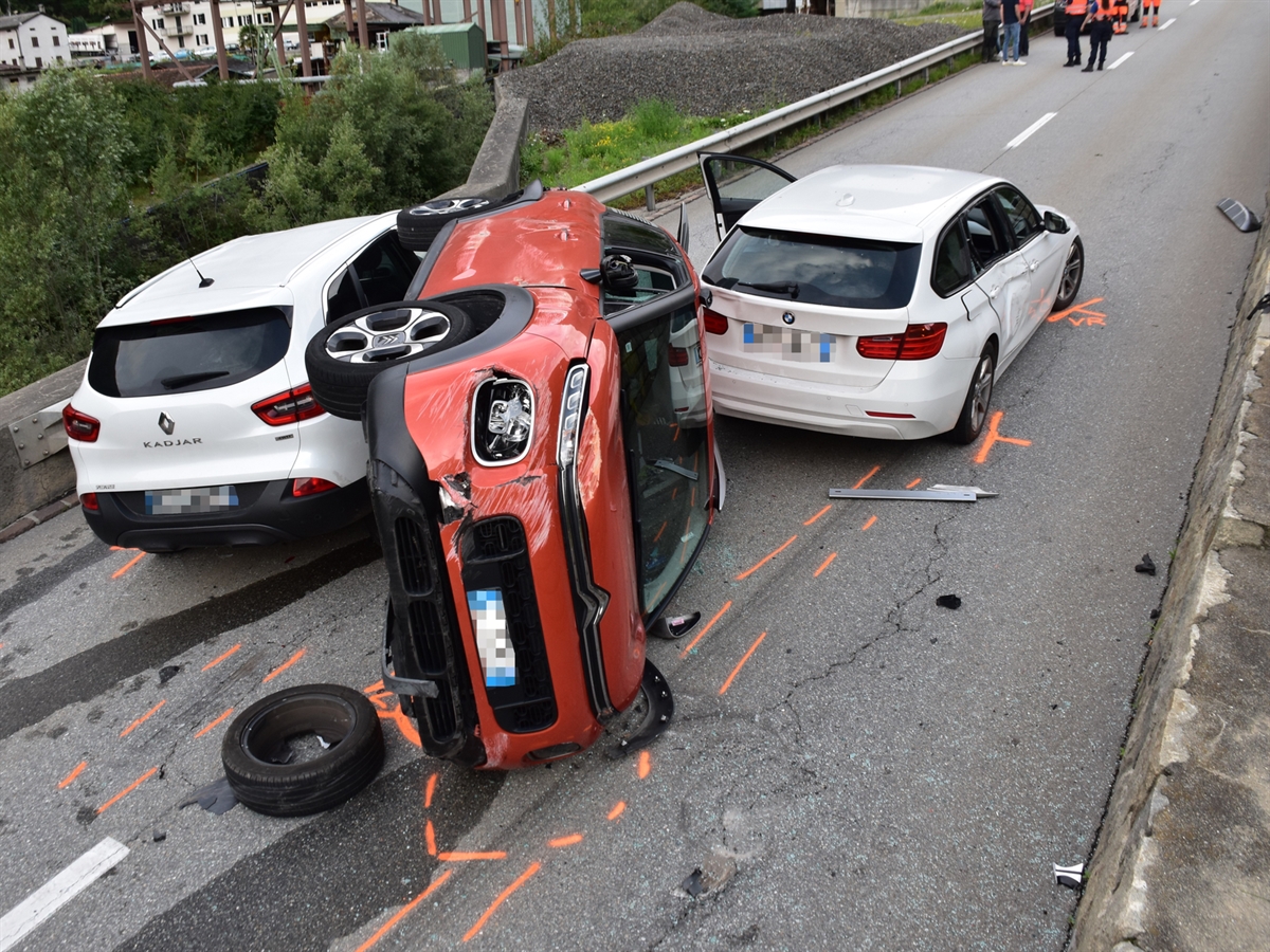 Zwischen zwei weissen Autos liegt das rote Auto der Italienerin auf der Seite.