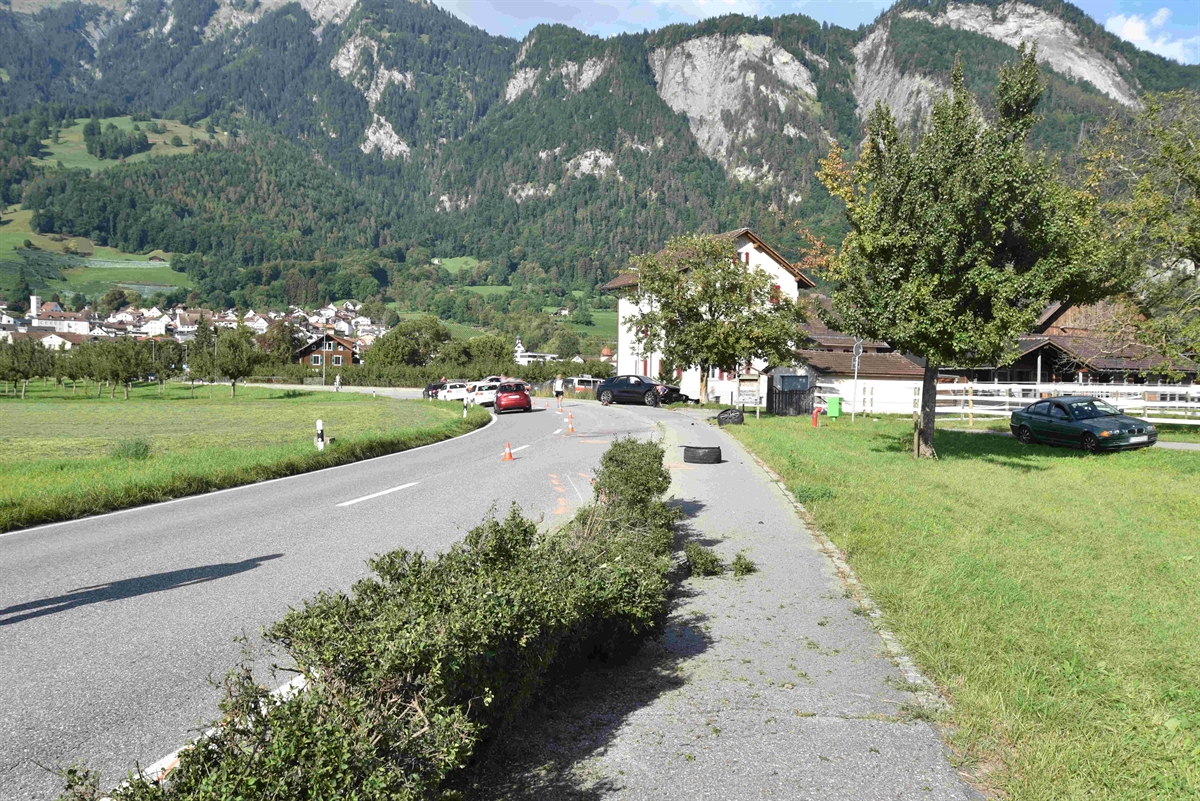 Übersichtsaufnahme in Richtung Landquart. In der Mitte liegt das abgerissene Rad auf dem Veloweg und im Hintergrund der andere Unfallwagen mit Front zu einem Baum.