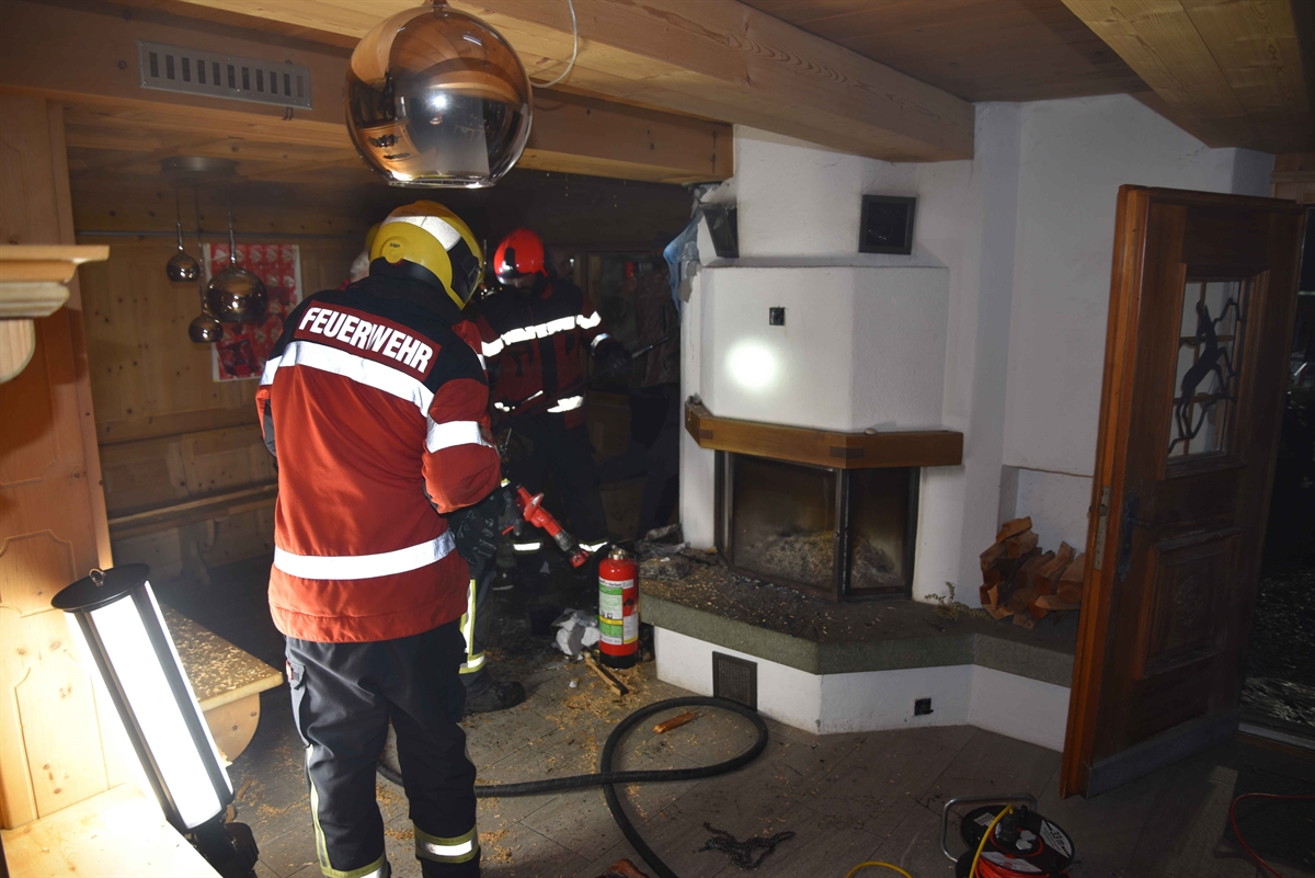 Zwei Feuerwehrleute stehen Berggasthaus in der Wohnstube mit Holzdecke und Cheminée im Zentrum 