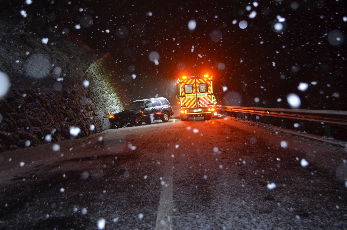 Links der verunfallte Personenwagen, rechts das Ambulanzfahrzeug der Rettung bei starkem Schneefall