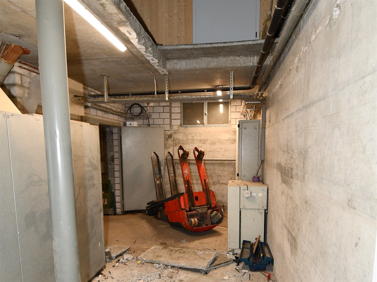 Der Elektrostapler liegt im Gebäudeinnern gekippt am Boden. Dort liegen beschädigte Betonplatten. Oben gut erkennbar die Öffnung in den oberen Stock.