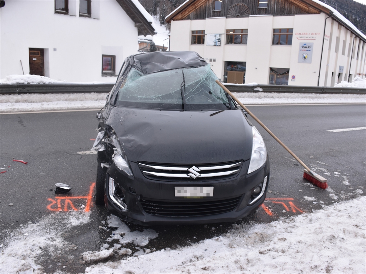 Ein schwarzer Kleinwagen mit stark eingedrücktem Dach. Im Hintergrund ein Haus.