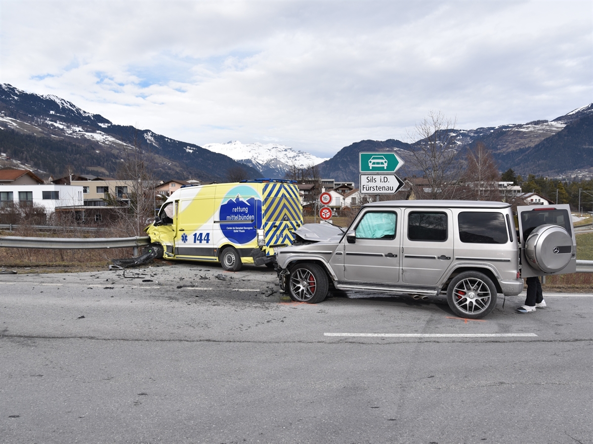 Rechts ein grauer Geländewagen mit beschädigter Front. Links davon der Rettungswagen an einer Leitplanke.