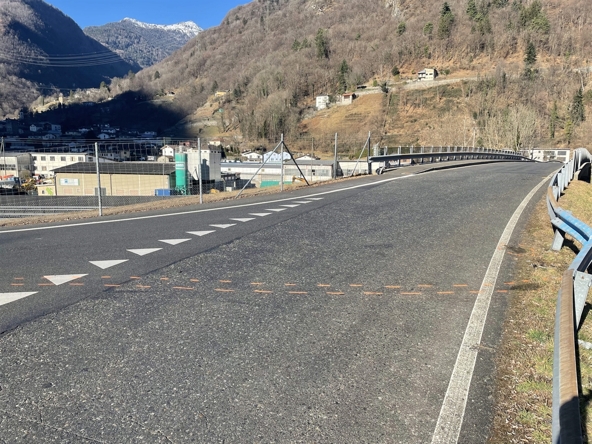 Querverbindungsstrasse mit Blick Richtung Rastplatz Campagnola. Rechtsseitig ist die stark beschädigte Leitplanke. Es ist eine grosse Delle zu sehen. Auf der Fahrbahn sind die Spuren mit roter Kreide eingezeichnet.