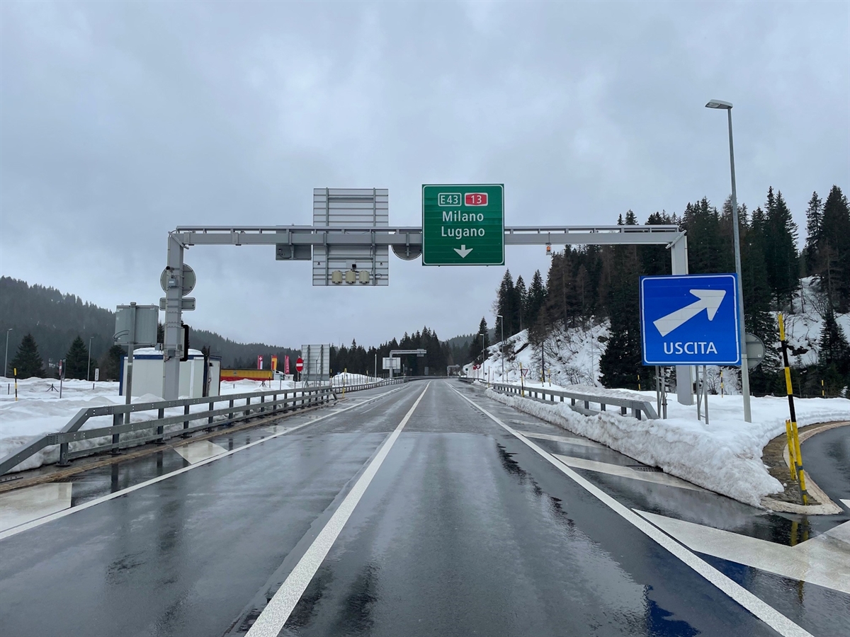 Die A13 in Richtung Süden gesehen. Rechts die Ausfahrt, oberhalb der Fahrbahn die Fernziele Milano / Lugano. Gut erkennbar die Sicherheitslinie in Strassenmitte.