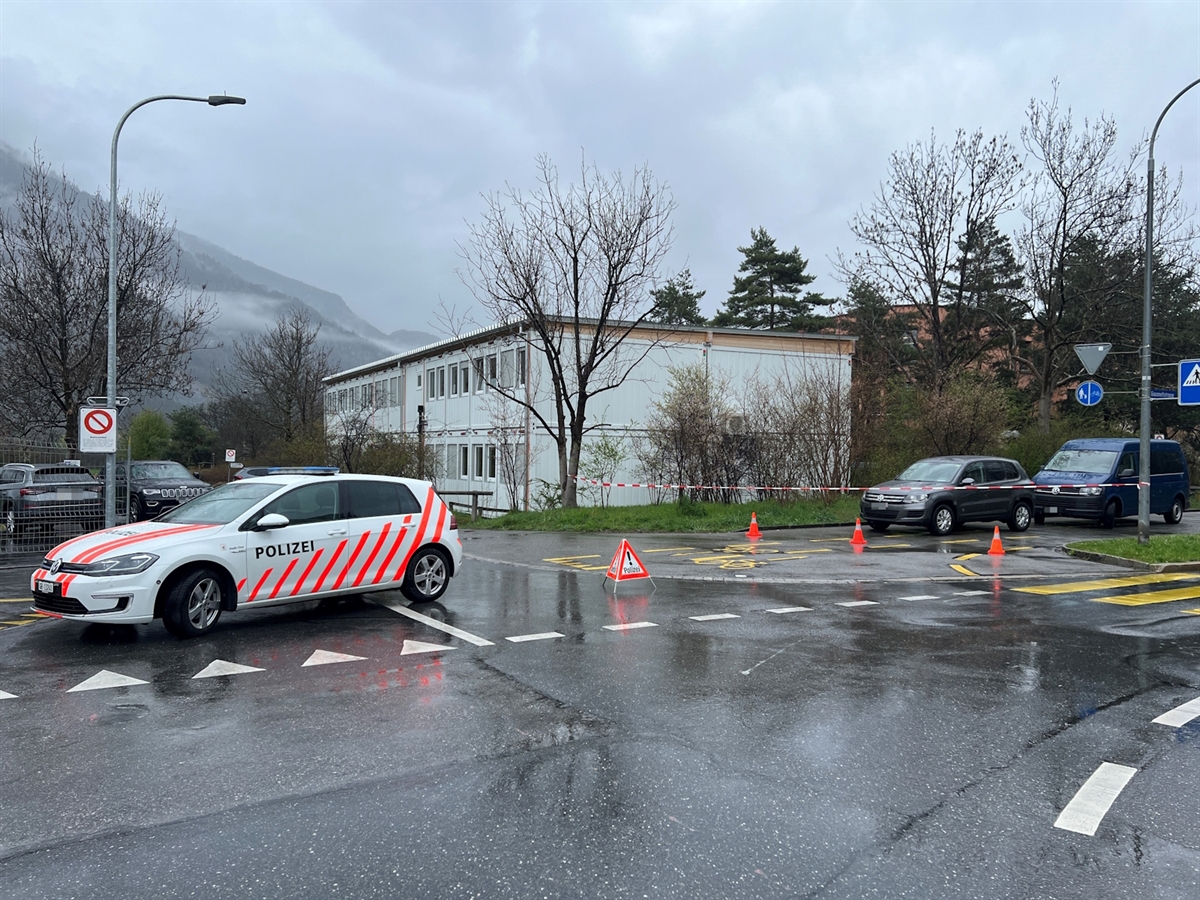 Ein Polizeiauto an einer Kreuzung, dahinter abgesperrtes Areal.