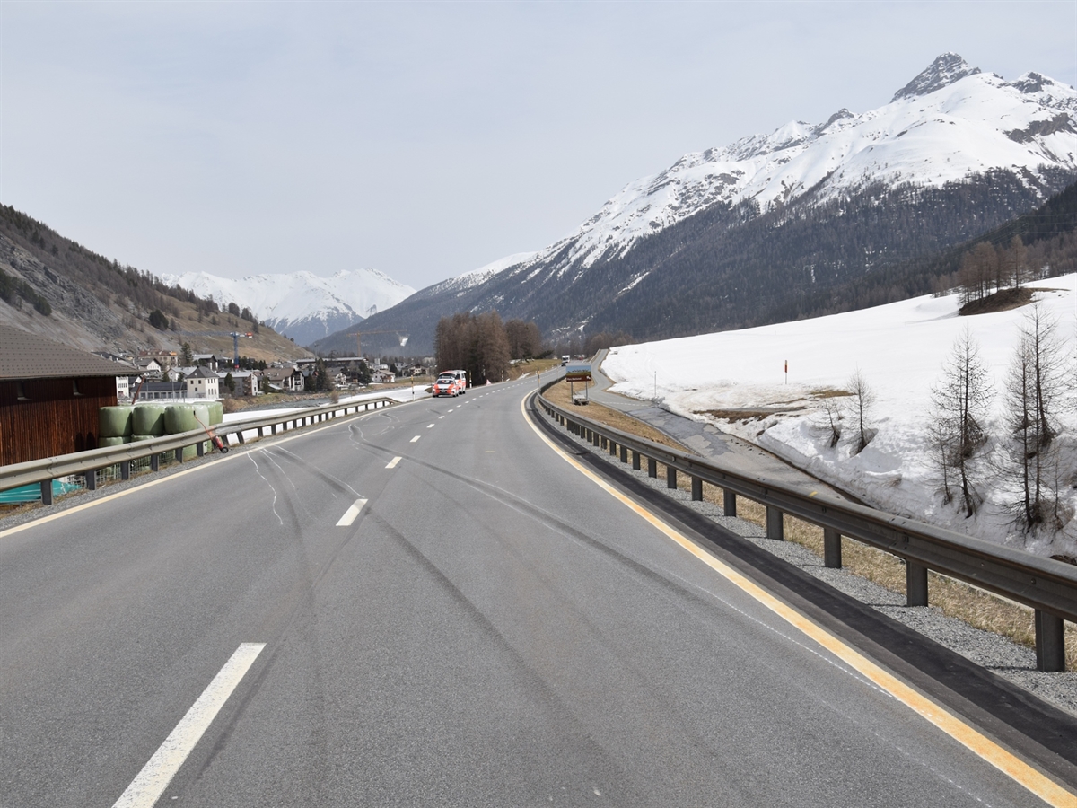 Links und rechts der Fahrbahn Leitplanken. Eingezeichnete Schleuderspuren. 