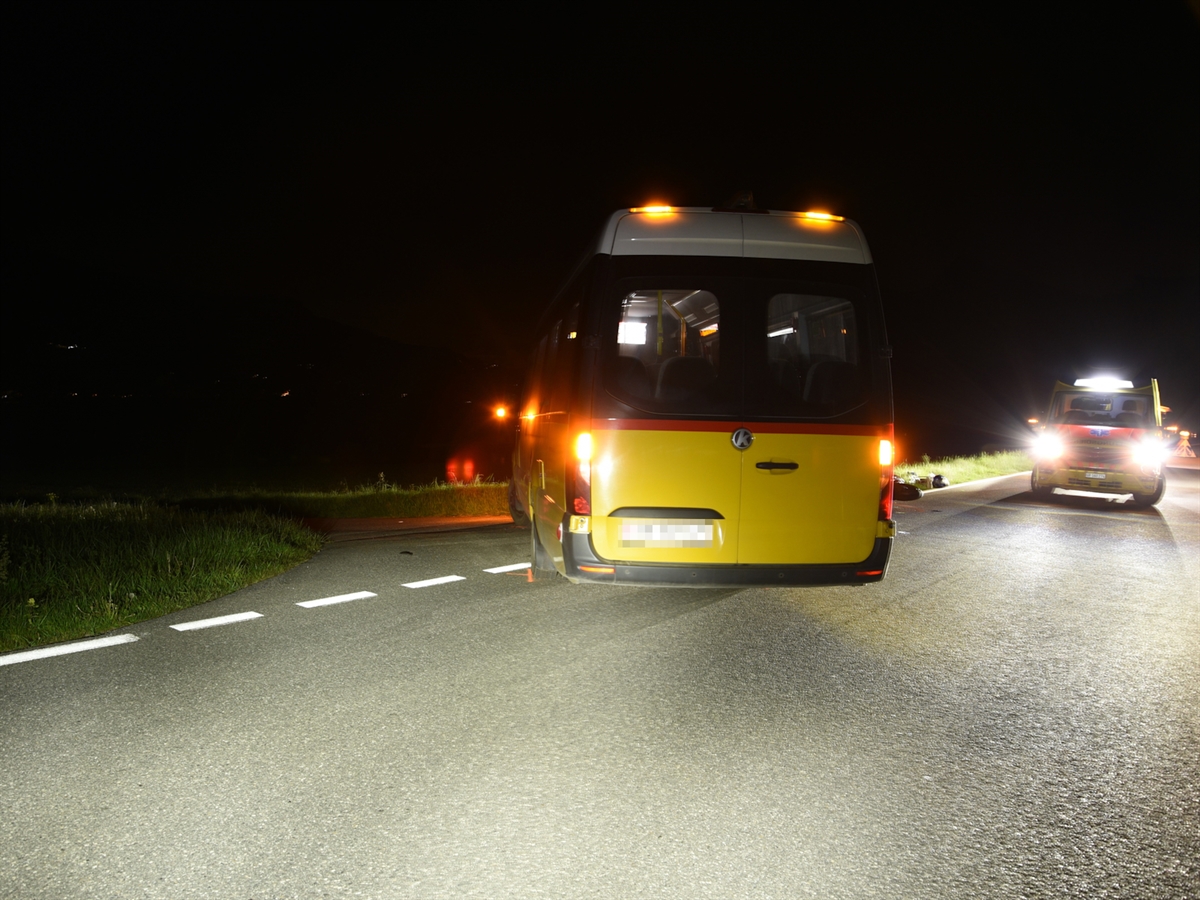 Der Bus mit Front in Richtung Nebenstrasse Richtung Mühle. Rechts davon liegt im Bereich der Kreuzung der Roller. Neben diesem Steht ein Rettungswagen der Rettung Chur. Hinter dem Rettungswagen wird die Unfallstalle mit einem Faltsignal gekennzeichnet.