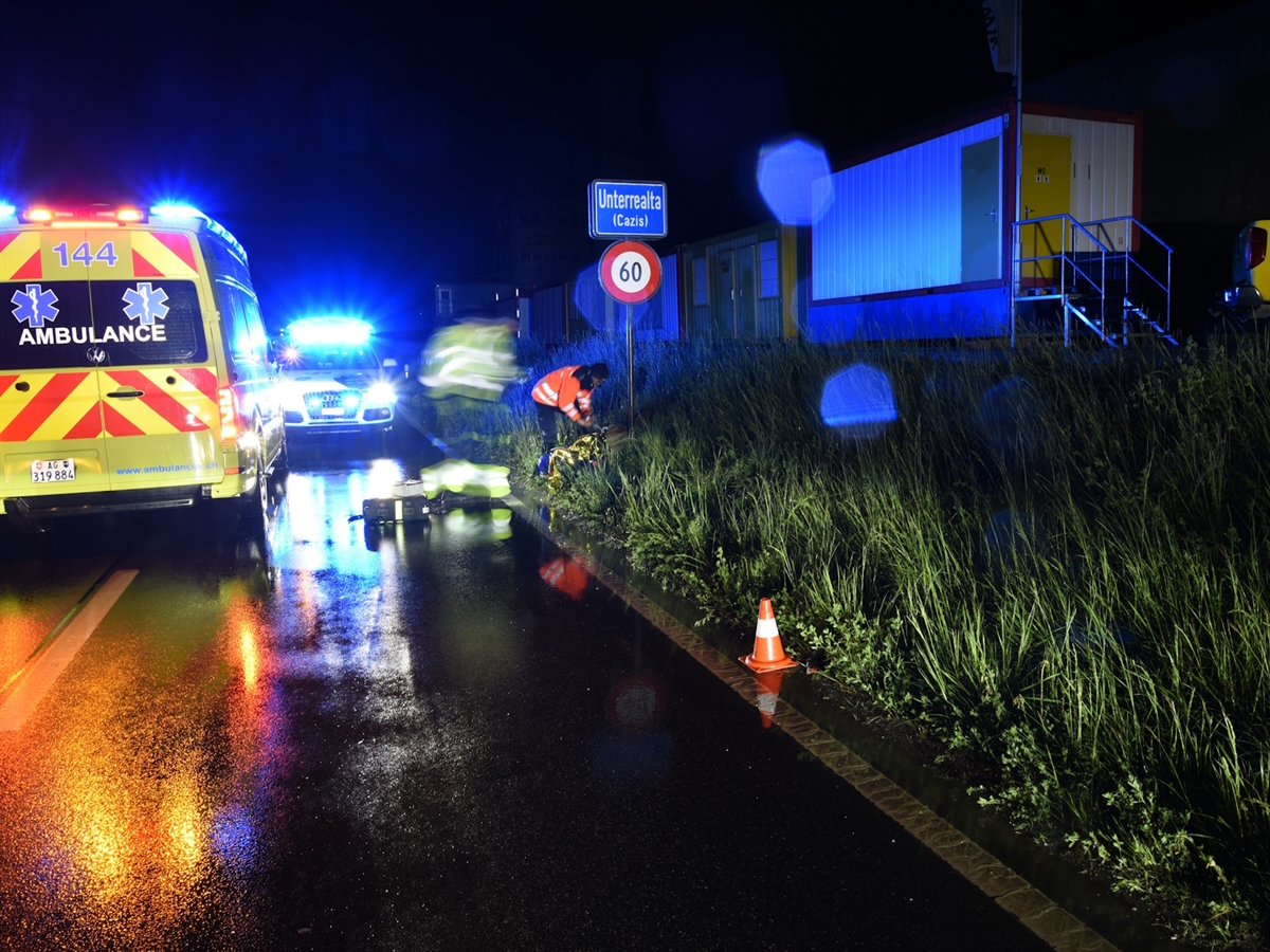 Nachtaufnahme. Links ein Rettungswagen, dahinter ein Notarztwagen. Rechts an der Böschung ein Polizist.