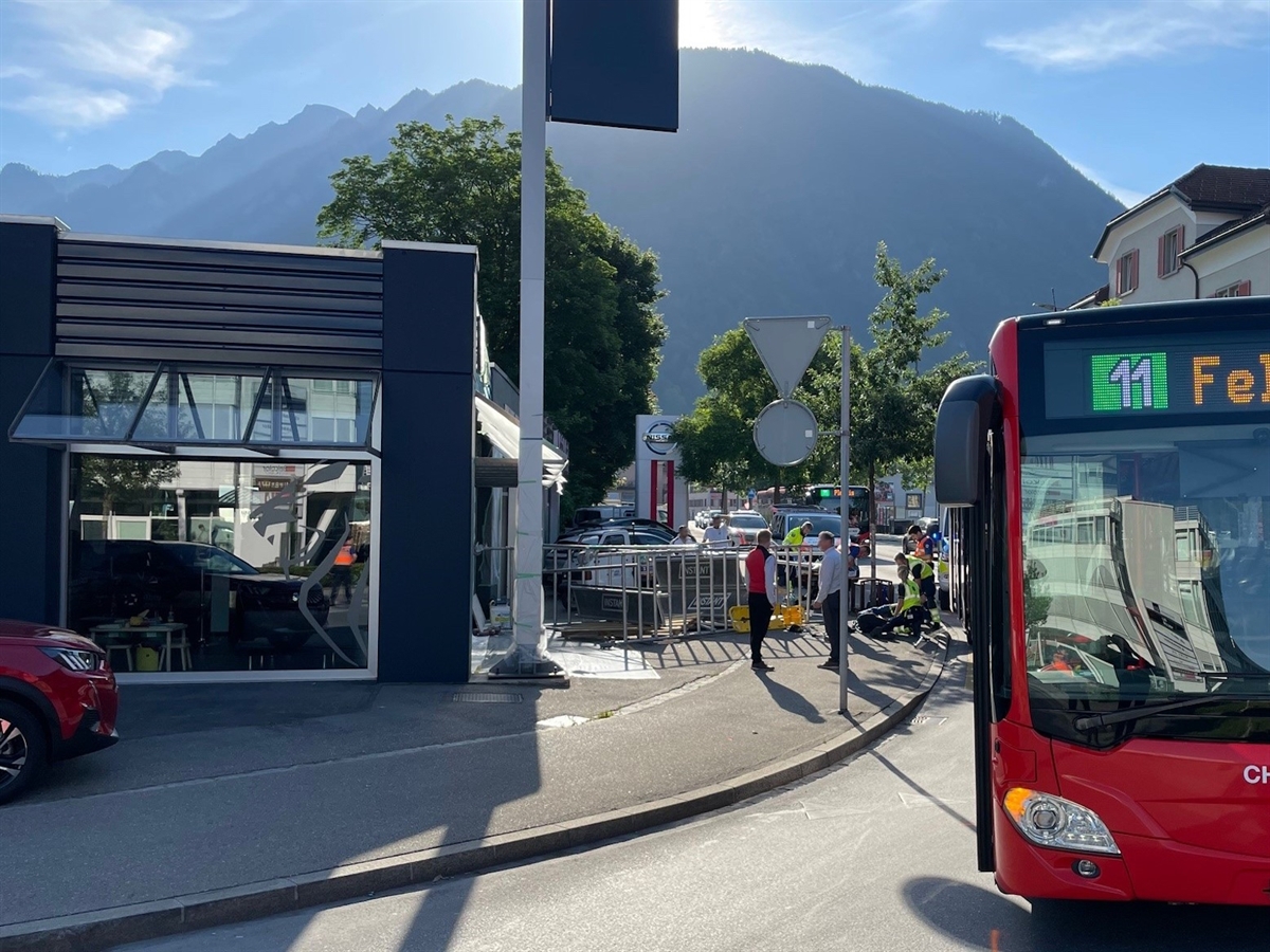 Rechts der Linienbus von vorne. Links davon im Hintergrund das umgestürzte Gerüst und ein Team der Rettung im Einsatz beim verletzten Senior.
