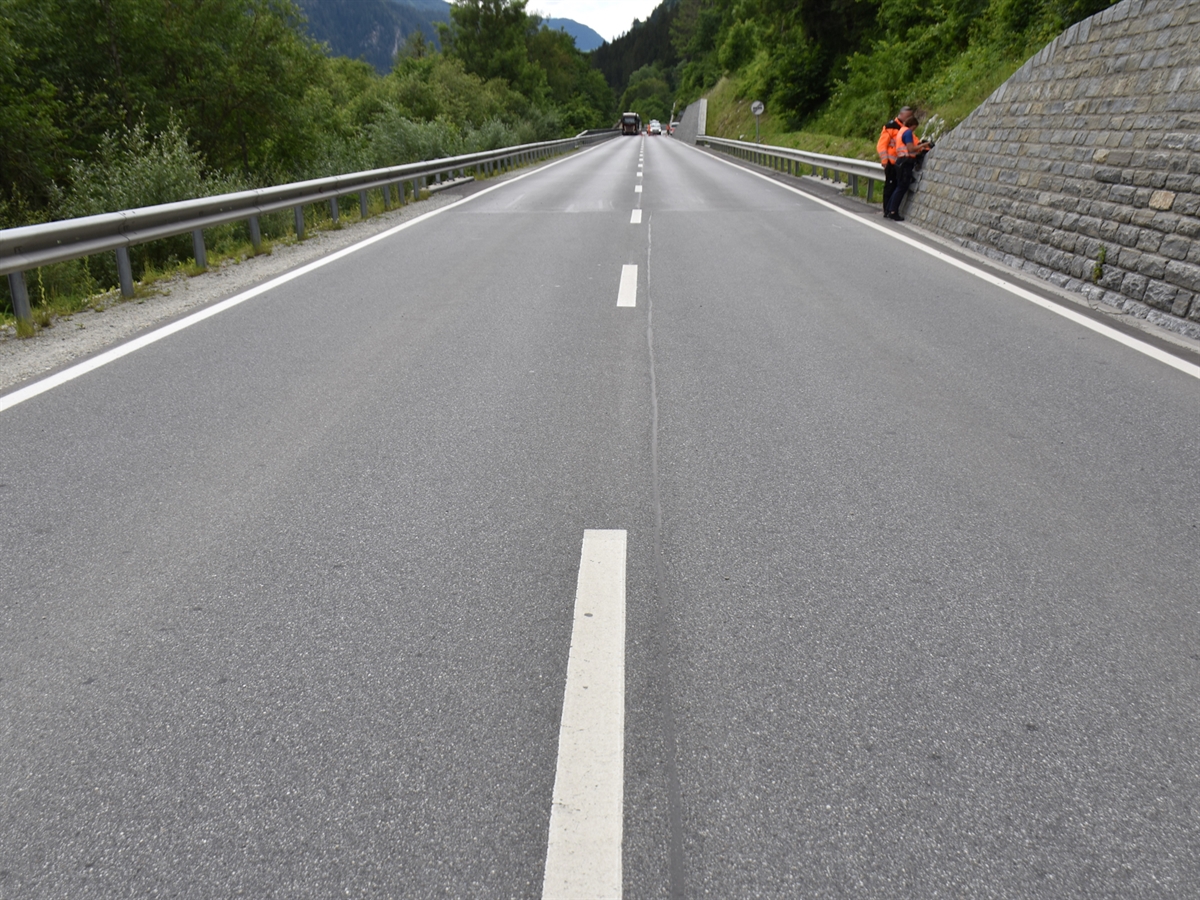Die Oberalpstrasse mit beidseitiger Leitplanke. Zwei Einsatzkräfte der Polizei machen Notizen zu der Unfallstelle.