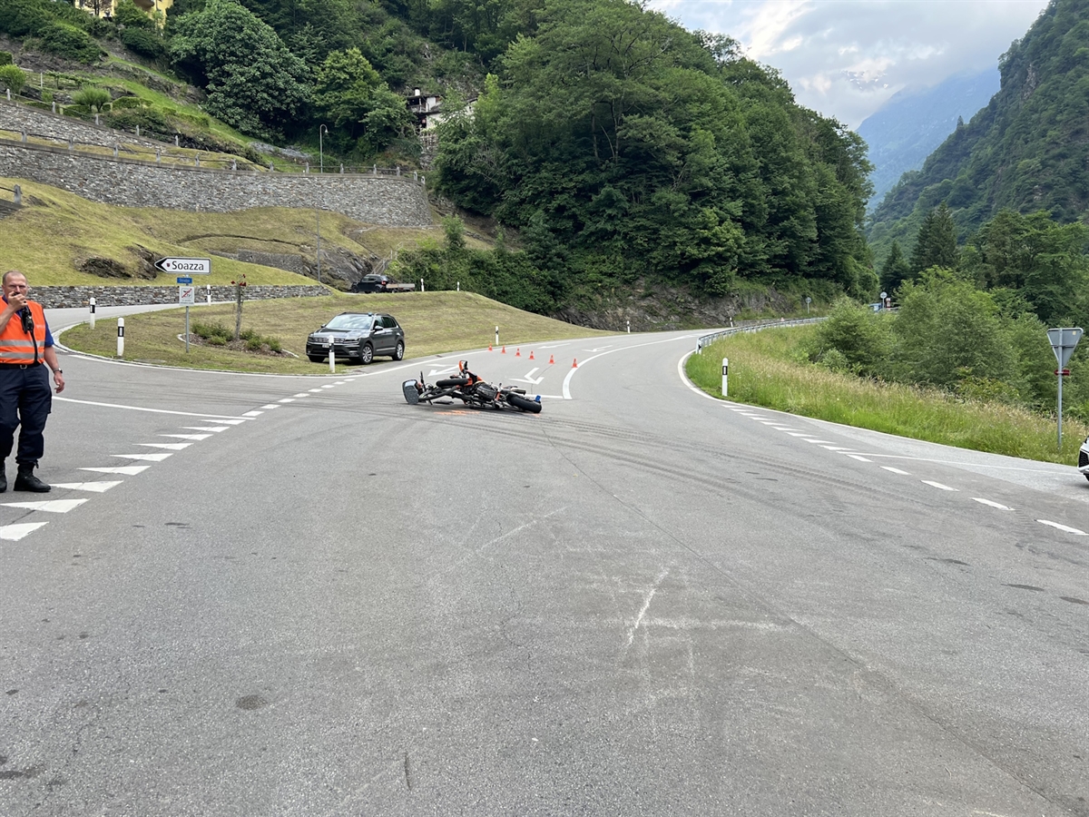 Auf der Verzweigung liegen das Motorrad und das E-Bike. Links führt eine Strasse nach Soazza hoch, auf welcher ein Polizist steht. 