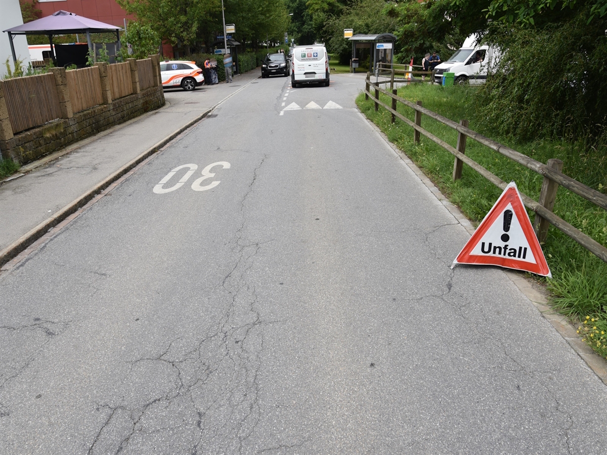 Inmitten einer Verzweigung der Lieferwagen. Links davon ein Fahrzeug der Rettung. Im Vordergrund ein Faltsignal mit der Aufschrift 