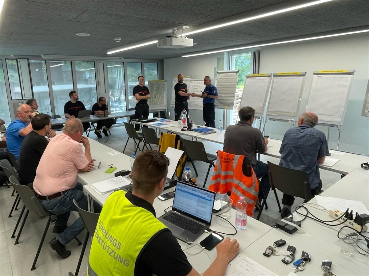 Einsätzkräfte in einem Raum bei der Übergabe der Einsatzleitung.