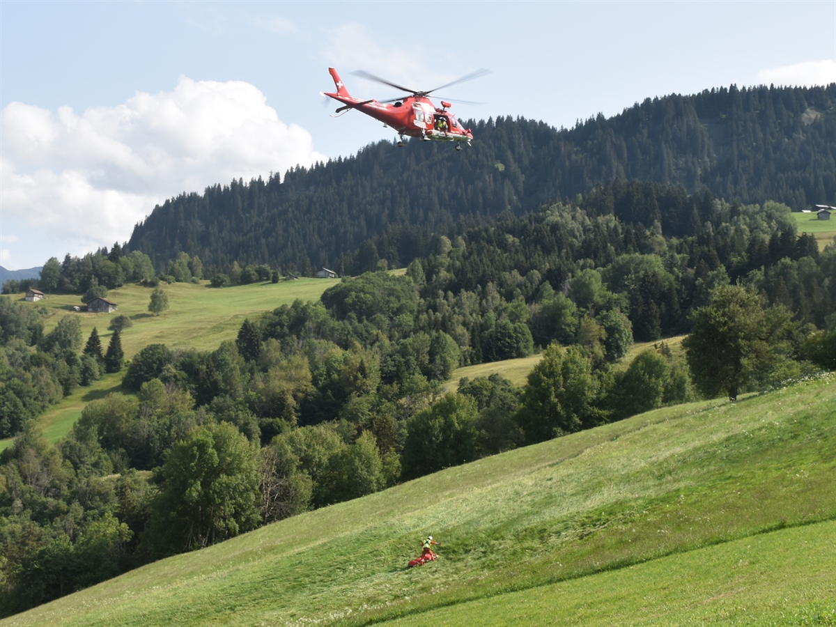 Der Helikopter der Rega schwebt über dem Abgestürzten in der Luft und hat den Arzt beim Verletzten abgesetzt.
