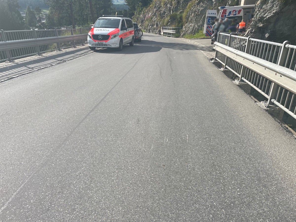 Ein Polizeiauto steht am Ende der Brücke, auf welcher die Fahrradfahrerin verunfallte. Rechts davon ein Rettungswagen und Personen, welche sich um die Verletzte kümmern