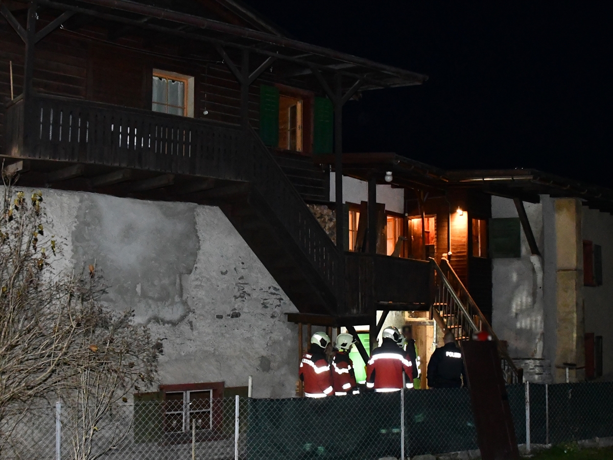 Einsatzkräfte der Feuerwehr sowie der Polizei besprechen nach dem erfolgreich gelöschten Brand die Lage vor dem Haus.